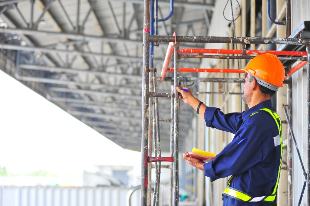 man inspecting scaffolding for maintenance